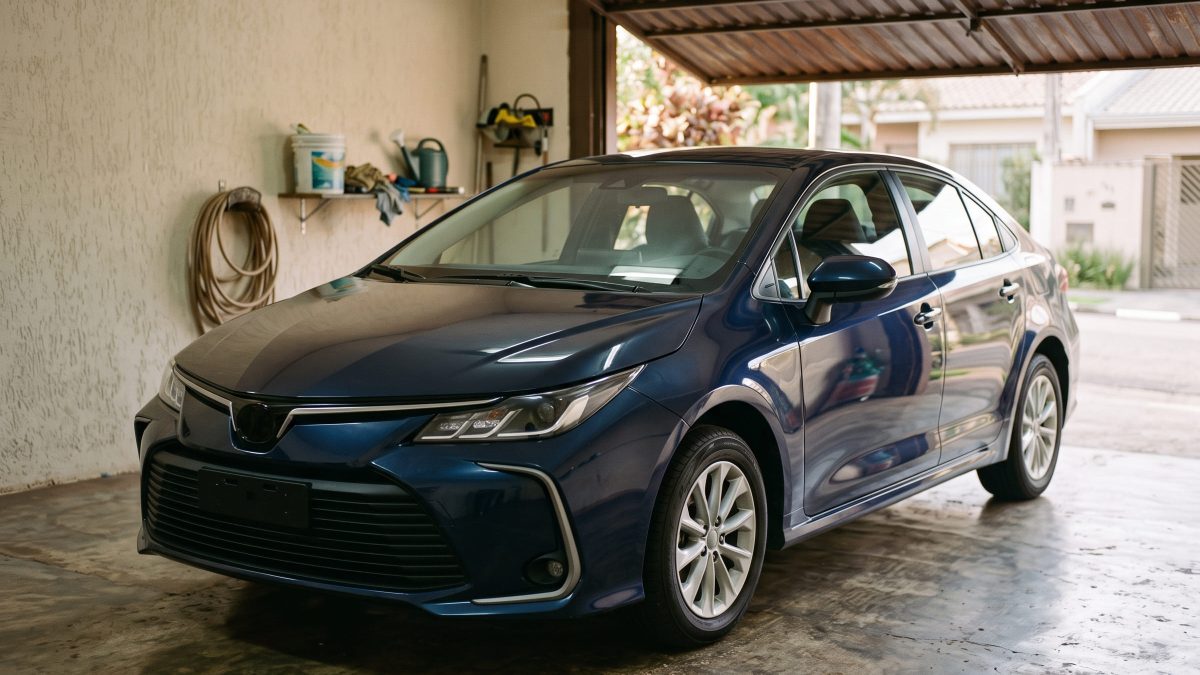 Toyota Corolla Hybrid azul estacionado em garagem residencial.