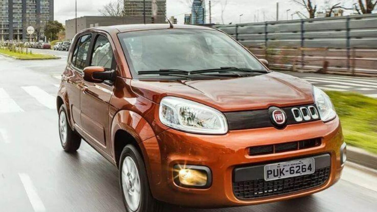 Fiat Uno em movimento na rua, visto de frente.