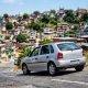Volkswagen Gol prata descendo uma ladeira íngreme em bairro brasileiro, ilustrando o uso do freio motor.