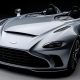 Foto em estúdio de um carro esportivo conversível cinza, com faróis dianteiros detalhados, grade frontal, design aerodinâmico moderno, sem a presença de para-brisa em fundo escuro e iluminação suave.