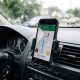 Suporte de celular fixado na saída de ar do painel do carro com smartphone exibindo rota no GPS.