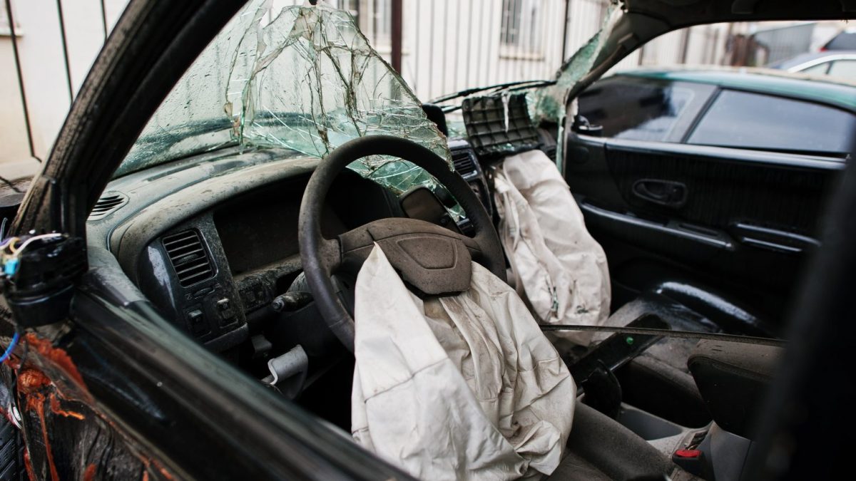 Airbags do motorista e do passageiro acionados após uma colisão, vistos de dentro do carro.