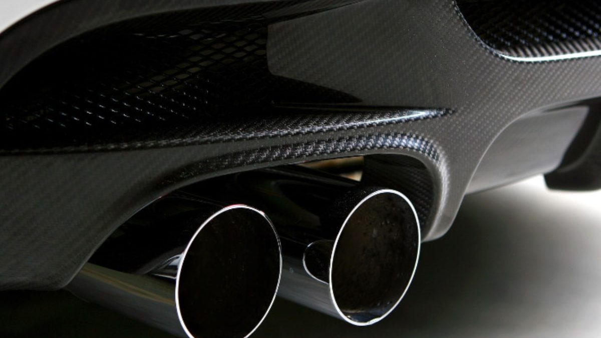 Ponteiras duplas de escapamento em carro esportivo com acabamento em fibra de carbono.