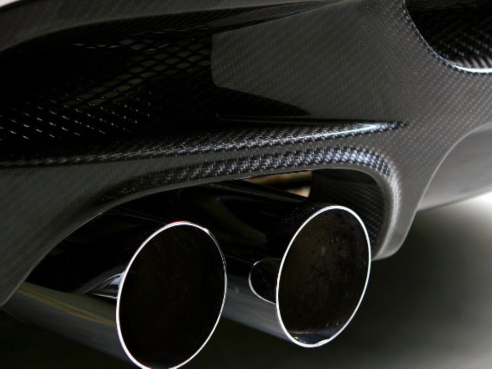 Ponteiras duplas de escapamento em carro esportivo com acabamento em fibra de carbono.