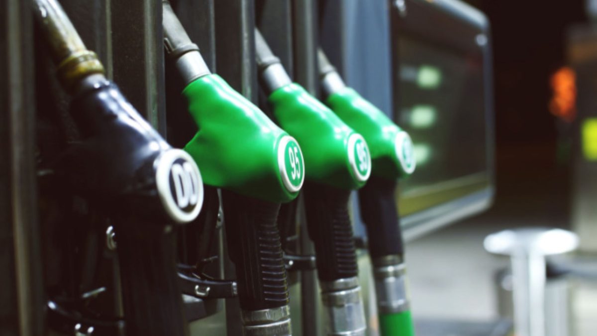 Fileira de bicos de bomba de combustível em um posto de gasolina, um preto e três verdes lado a lado.
