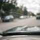 Risco fino no para-brisa visto de dentro do carro, seguindo a área de varredura da palheta.