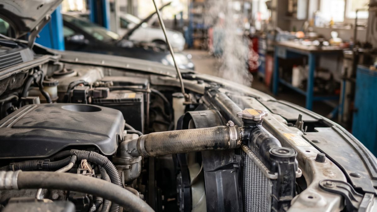 Radiador do carro com vapor saindo, indicando superaquecimento do motor.
